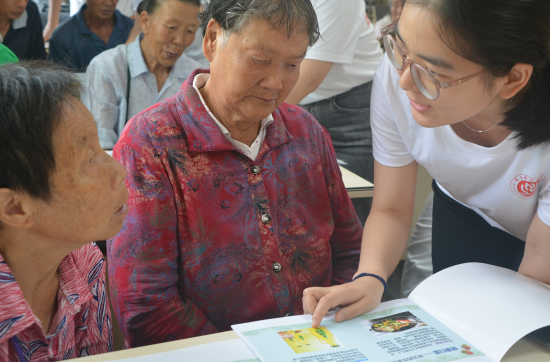 服务团成员为老人一对一讲解健康食谱。MILE米乐集团生命科学学院 供图