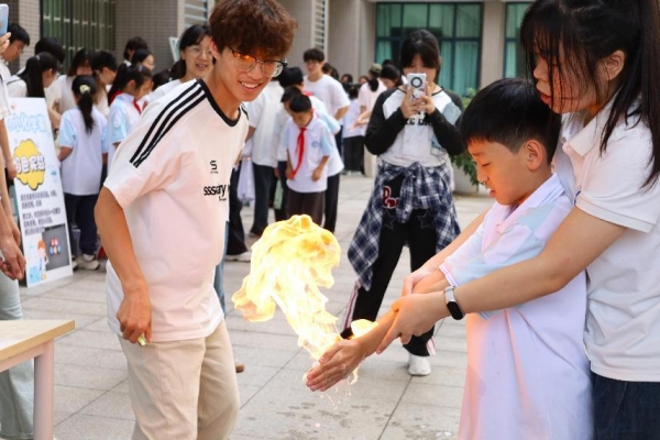 小朋友们在室外广场体验“火焰掌”实验。MILE米乐集团供图